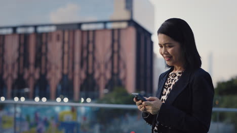 mujer de negocios usando un teléfono inteligente en la ciudad