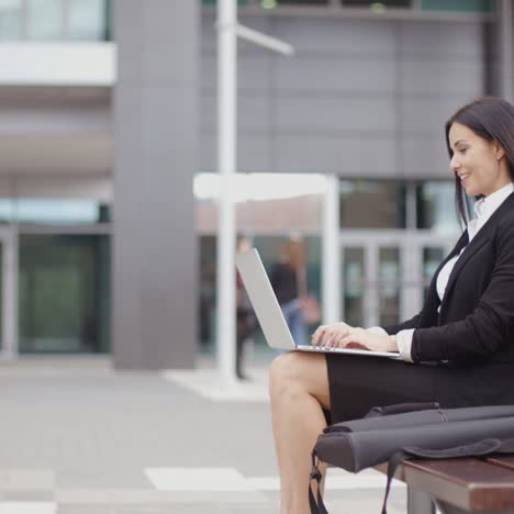 Vista-Lateral-De-La-Mujer-Sola-Con-El-Portátil-En-El-Banco