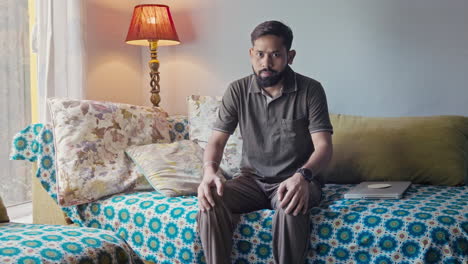 man experiencing knee pain while sitting on a couch