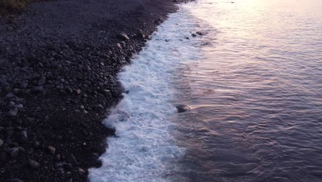 Flyover-Madeira-Island-rocky-beach-with-Waves-rolling-on-Shore,-Slow-motion