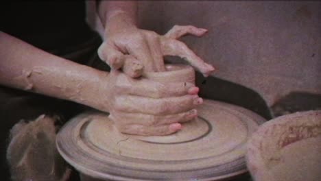 un alfarero enseña a una mujer a hacer platos de arcilla. un hombre toma las manos de una mujer. efecto vintage.