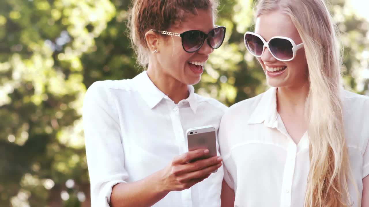 Amigos sorridentes usando smartphone