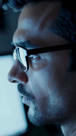 close-up of a man looking at a screen at night