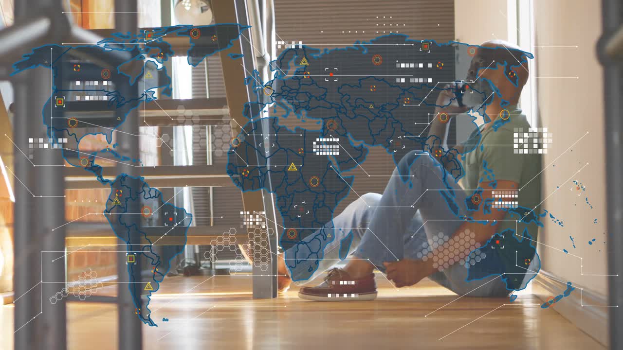 Voksen mann sitter på gulvet, løfter smarttelefon, starter et globalt teknologisk datakart med nettverksikoner