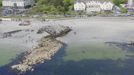 close up top down view of currach boats, quick tilt up to galway coast