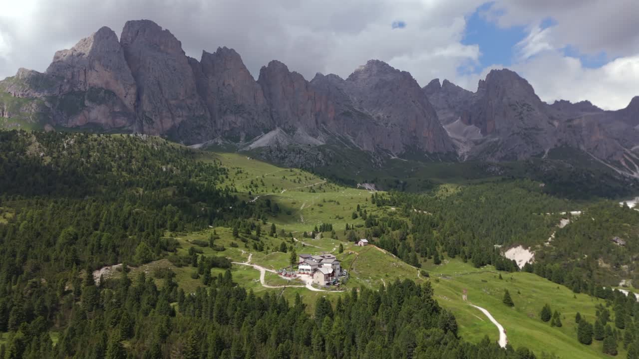 impresionante vista aérea de la cabaña de regensburger enclavada en los verdes valles de seceda, rodeada de altos picos y exuberantes bosques en los dolomitas