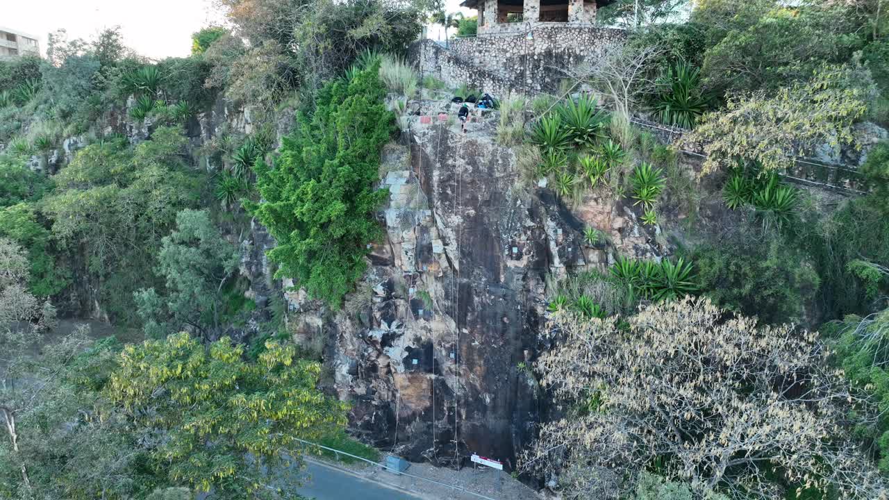 브리즈번의 캥거루 포인트 절벽을 내려가는 남자의 드론 패닝 샷, 일출 촬영