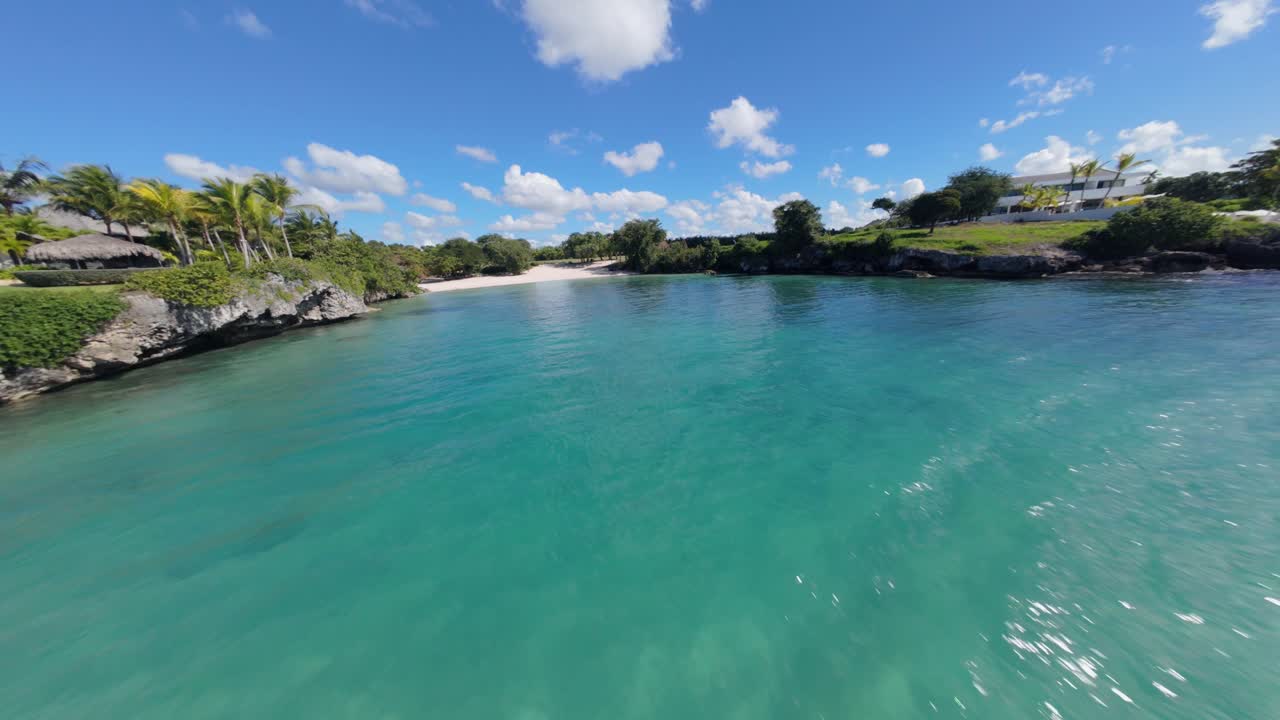 Caleton Beach with turquoise water of Caribbean sea in summer. Drone fpv shot. Paradise on earth on tropical island of Dominican Republic. Sun reflection on watet surface.
