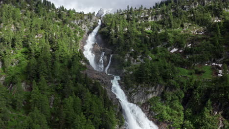 la cascada del rutor cae en cascada por la exuberante ladera verde de las montañas en los alpes