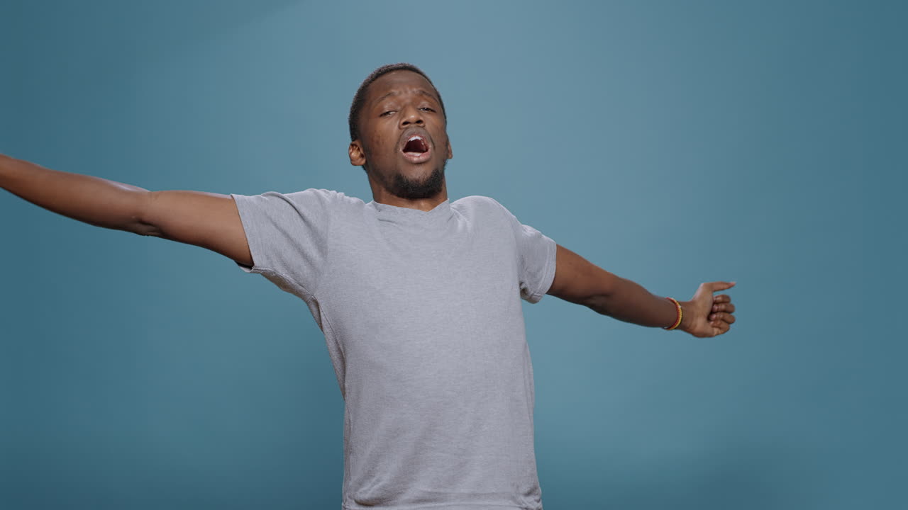 Tired overworked person yawning in front of camera in studio