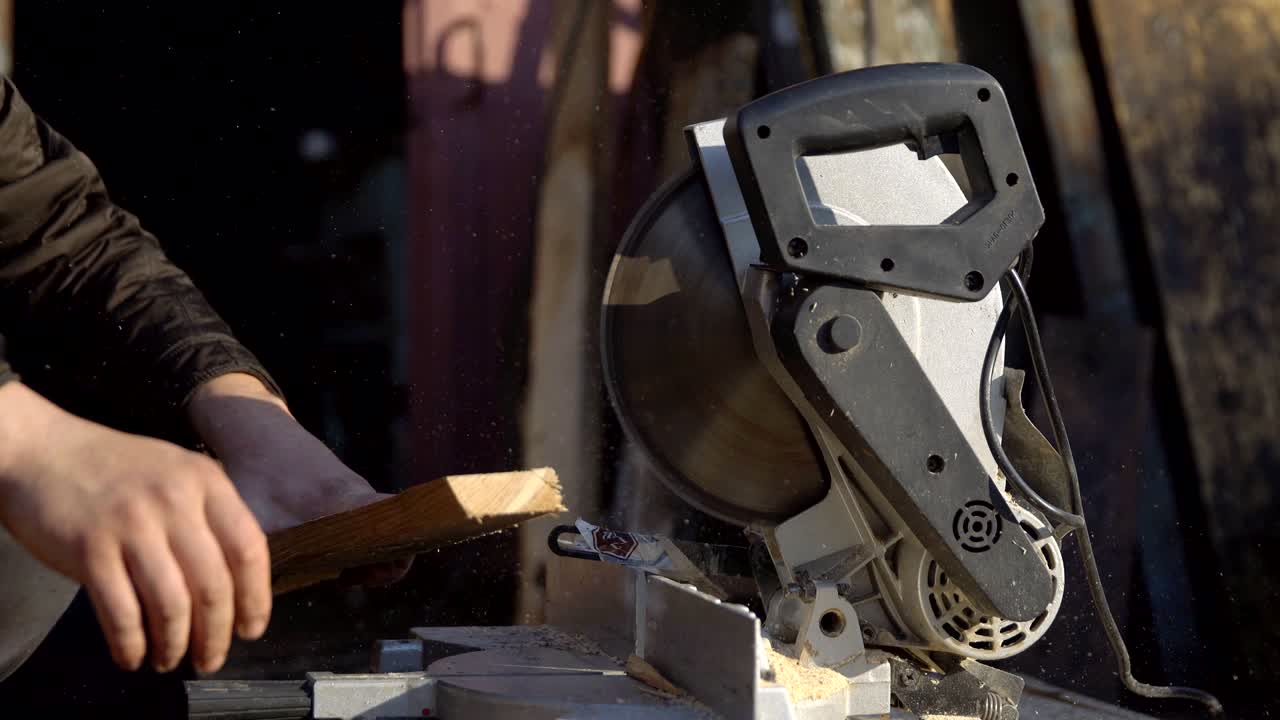 человек пилет доски с помощью круговой пилы
