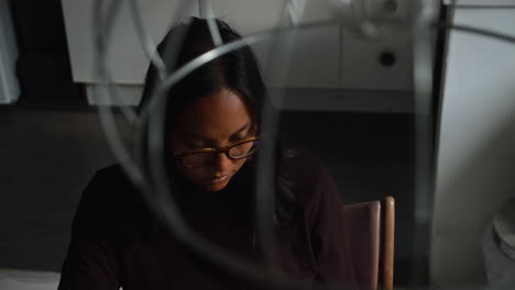 a high angle of an asian woman sitting at her laptop computer in her apartment using a laptop computer to work from home