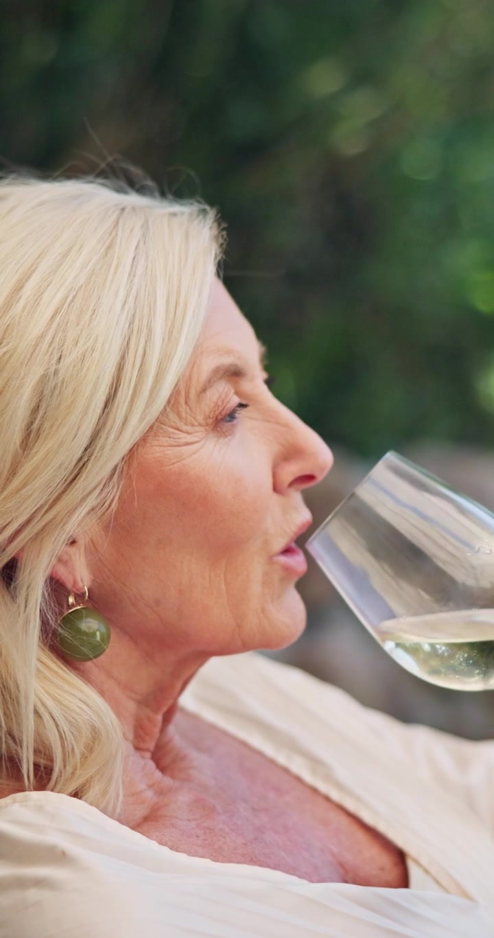 Mature Woman Enjoying a Glass of White Wine Outdoors