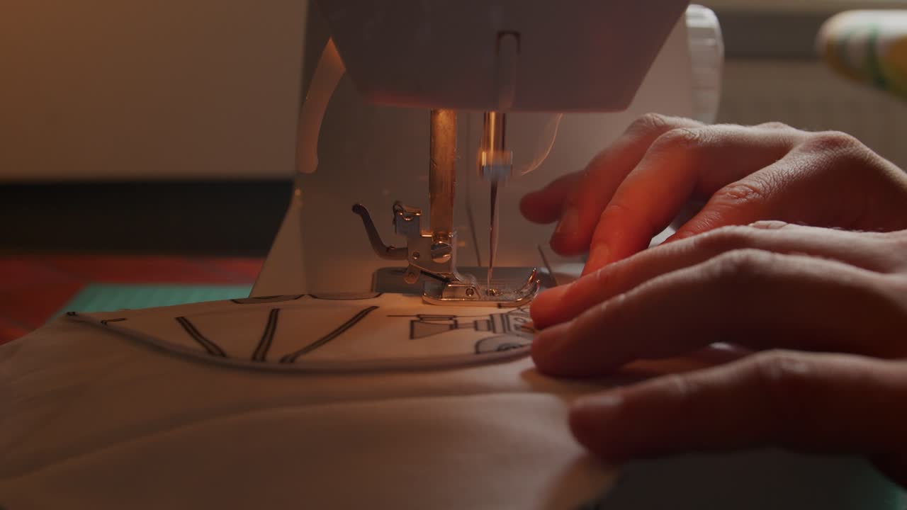 cámara lenta de la aguja en la máquina de coser que desciende y atrapa la tela