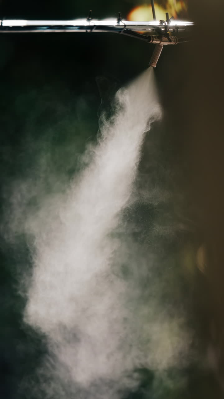 A jet of water spraying into the air against a dark background