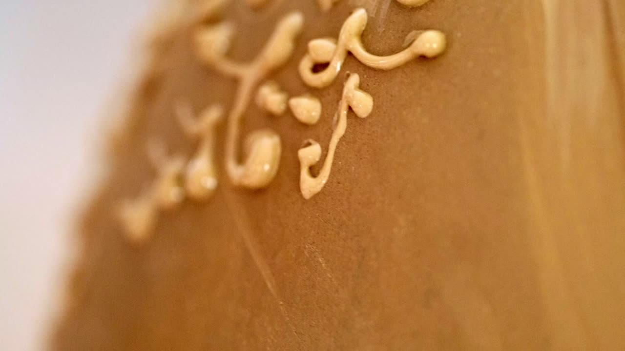 Artistic Craftsmanship in Focus: A Detailed View of Intricate Designs Being Applied on Clay, Showcasing the Precision of Handmade Pottery Techniques