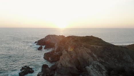 tourists admiring scenic sunset from punta cometa peninsula near mazunte in oaxaca, mexico