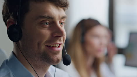 friendly agent speaking client in headset closeup. positive man specialist work