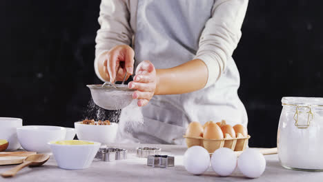 woman staining flour in sieve 4k