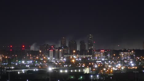 Lapso-De-Tiempo-Del-Hermoso-Paisaje-Urbano-Nocturno-Con-Humo-De-Fuego-Ardiente-En-El-Fondo