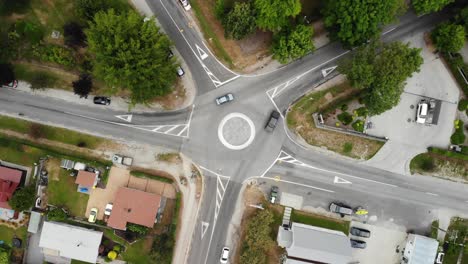 birdseye aerial view of light car traffic on 5 ways roundabout in small idyllic city