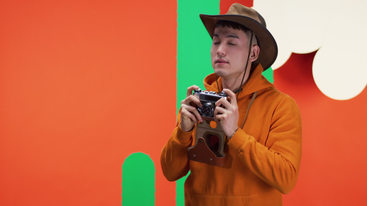 Man in Cowboy Hat Taking Pictures with Vintage Camera