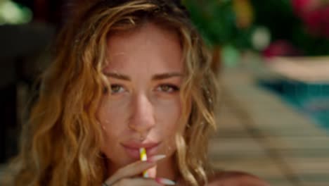 woman drinking by pool