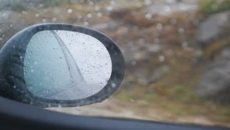 raindrops in stormy weather looking through window in the sidemirror