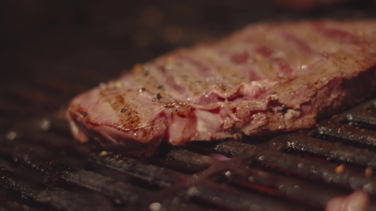 Close-up de Bife de Alcatra Cozinhando Suavemente ao Ar Livre à Noite na Churrasqueira. Culinária de Verão ao Ar Livre