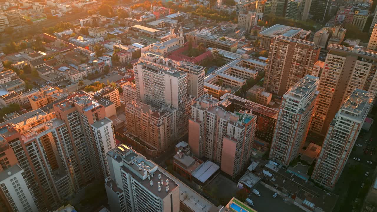 Santiago’s city towers glow in golden sunset light, showcasing a stunning urban skyline.