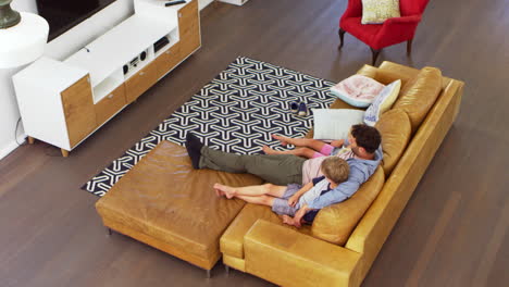 high angle view of father and children watching tv together