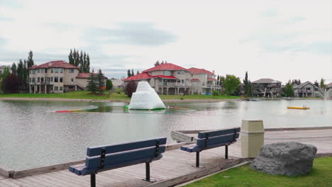 private lake and beach in a private nice neighbourhood with benches on an overcast day