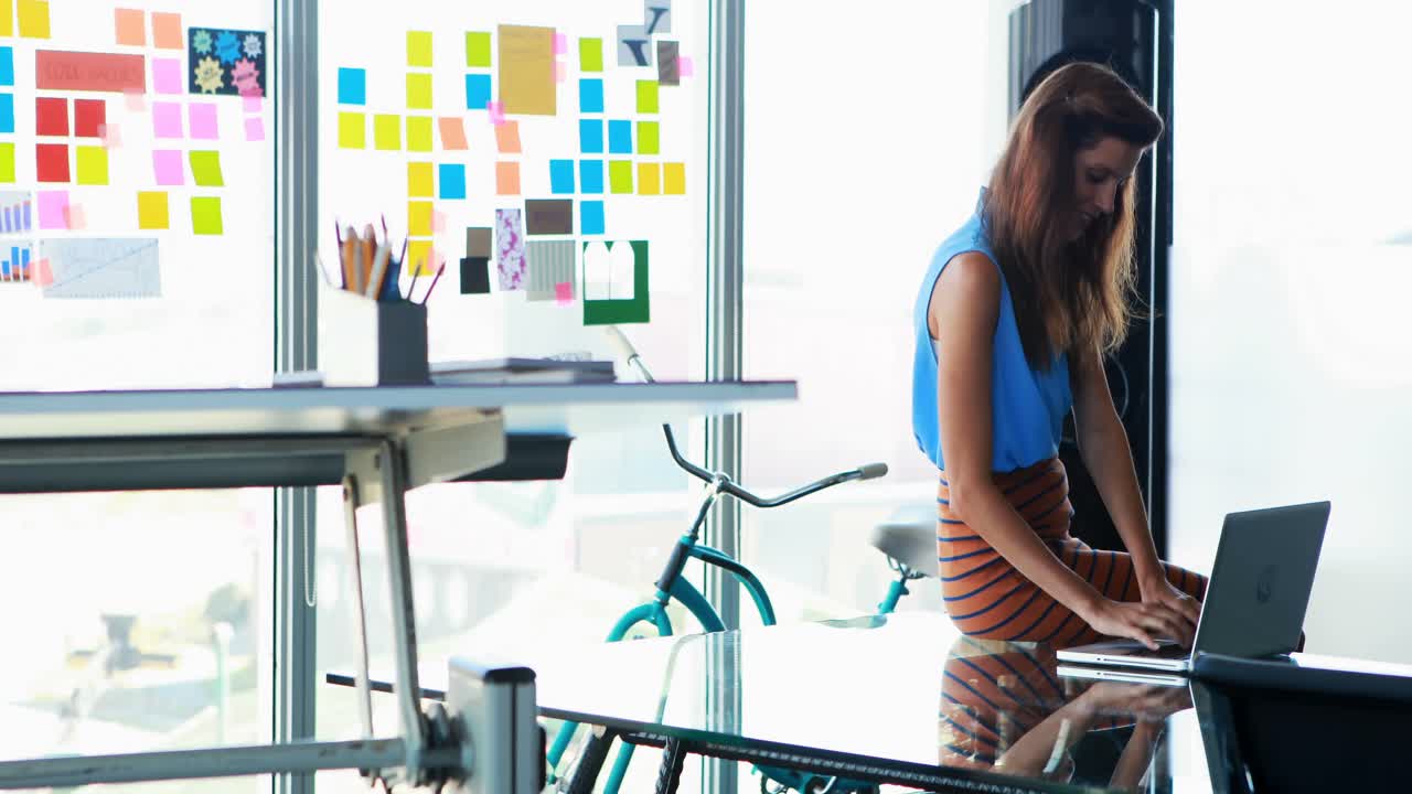 mujer ejecutiva usando una computadora portátil en el escritorio 4k