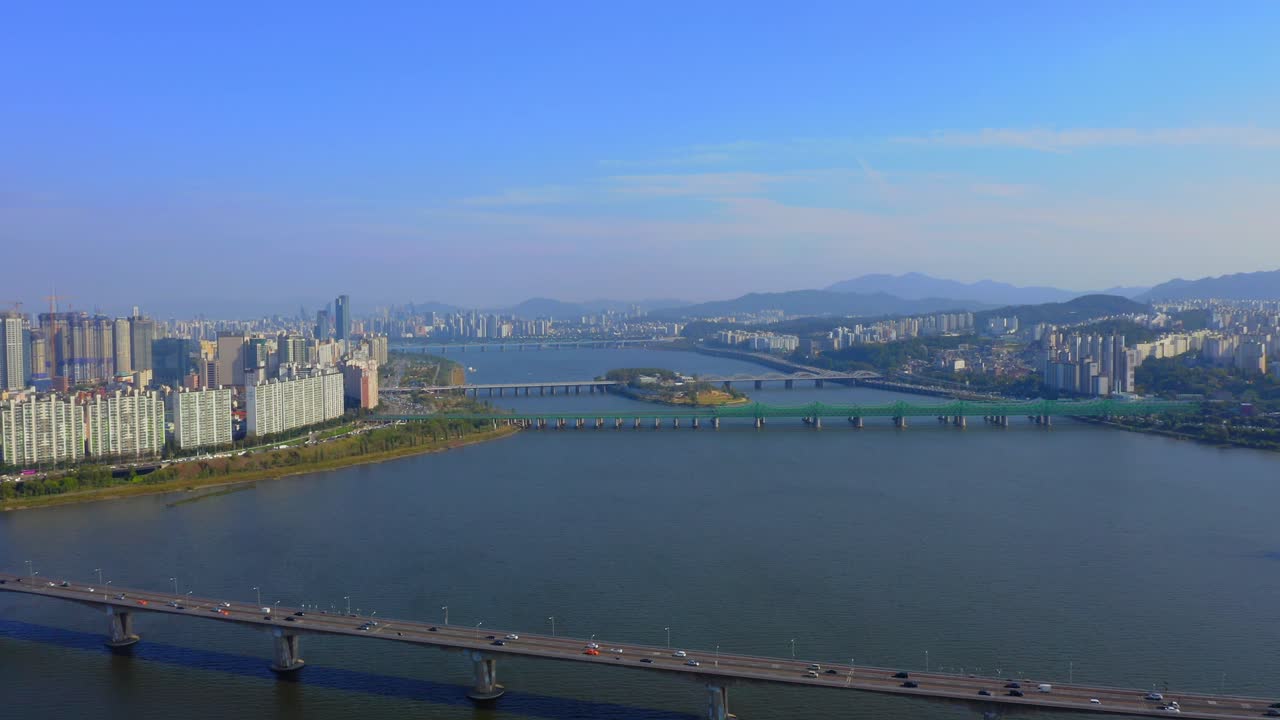 낮 동안 서울의 주거 지역이 보이는 한강 위로 앞으로 이동하는 드론 샷