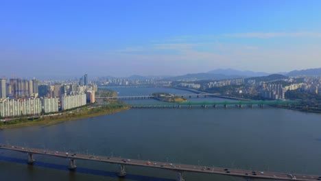 낮 동안 서울의 주거 지역이 보이는 한강 위로 앞으로 이동하는 드론 샷