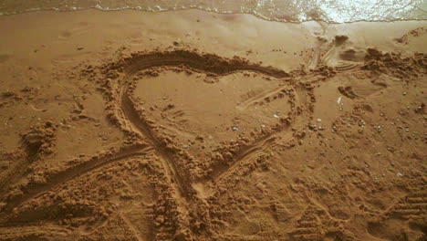 Herz-In-Den-Sand-Gezeichnet.-Strandsandhintergrund-Mit-Herz.