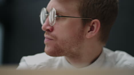 retrato de un hombre cansado y pensativo mirando la pantalla de una computadora portátil con gafas. un hombre de lluvia de ideas. resolución de problemas. pensar y trabajar