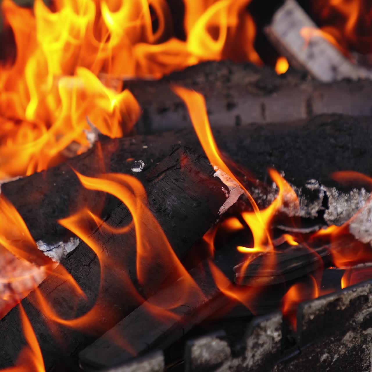 Tronchi ardenti tra le fiamme. Legna da ardere incandescente come sfondo astratto. Braci ardenti di legna nel fuoco. Primo piano