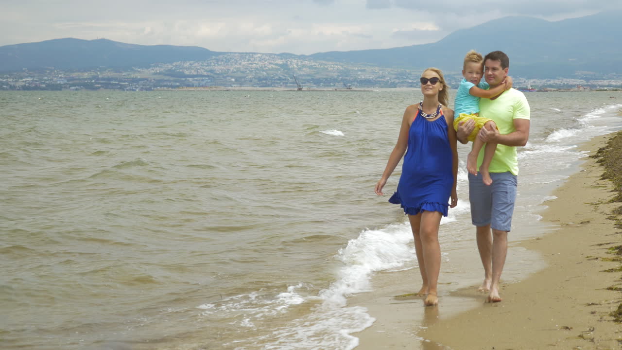 Padres e hijo disfrutando de un paseo al aire libre junto al mar