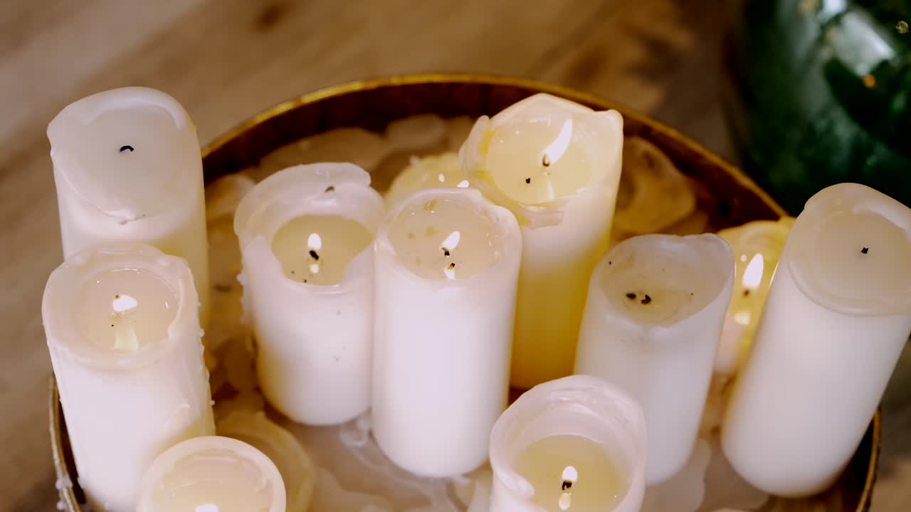 Cluster of white candles melted down in a warm, cozy setting