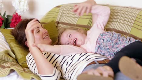 Mother-and-daughter-laughing-on-couch