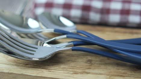 blue handle cutlery set on wooden board