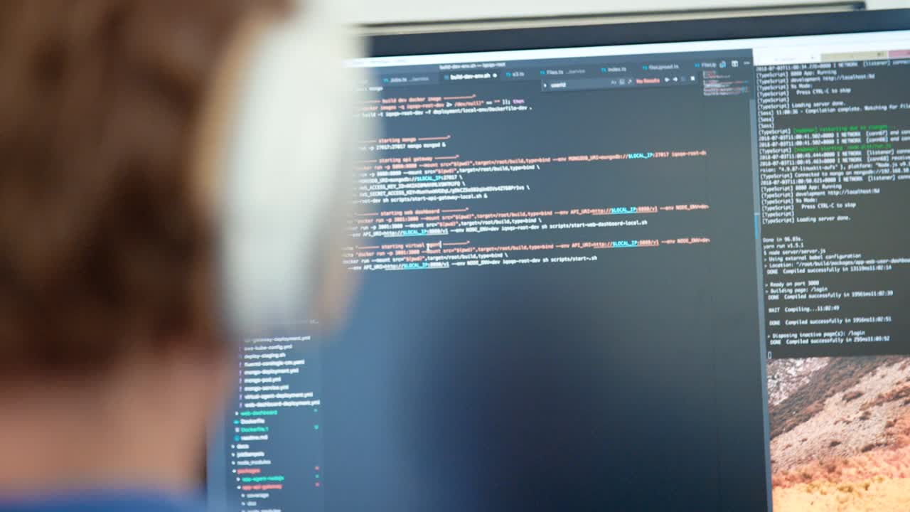 programador de computadora sentado frente a una pantalla codificando software