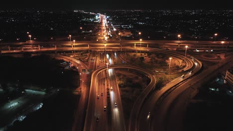 car traffic transportation on highway road intersection in bangkok city, thailand at night. public transport, commuter lifestyle, asian city life concept. drone aerial high angle view