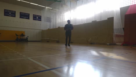 male rubbing his hands walking from wall - strong athletic muscular black man standing on basketball court looking around in 4k
