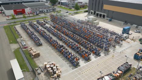 aerial wide angle drone footage of an electrical cable storage yard outside an industrial building