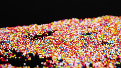 vibrant sprinkles cascade across a dark surface