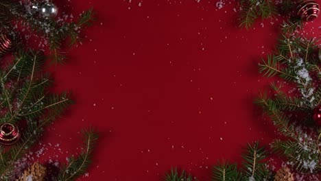 christmas background 360 degree rotation. christmas tree or fir branches,cones,snow and decorationsrotating on a red background. new year gifts, holiday and holiday shopping concept