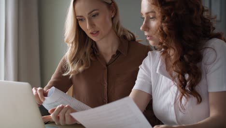 Two-women-working-together-at-home-office-about-new-project.