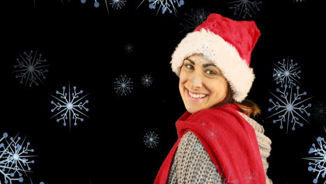 animación de una feliz mujer caucásica con gorra de santa y soplando un beso contra los copos de nieve.